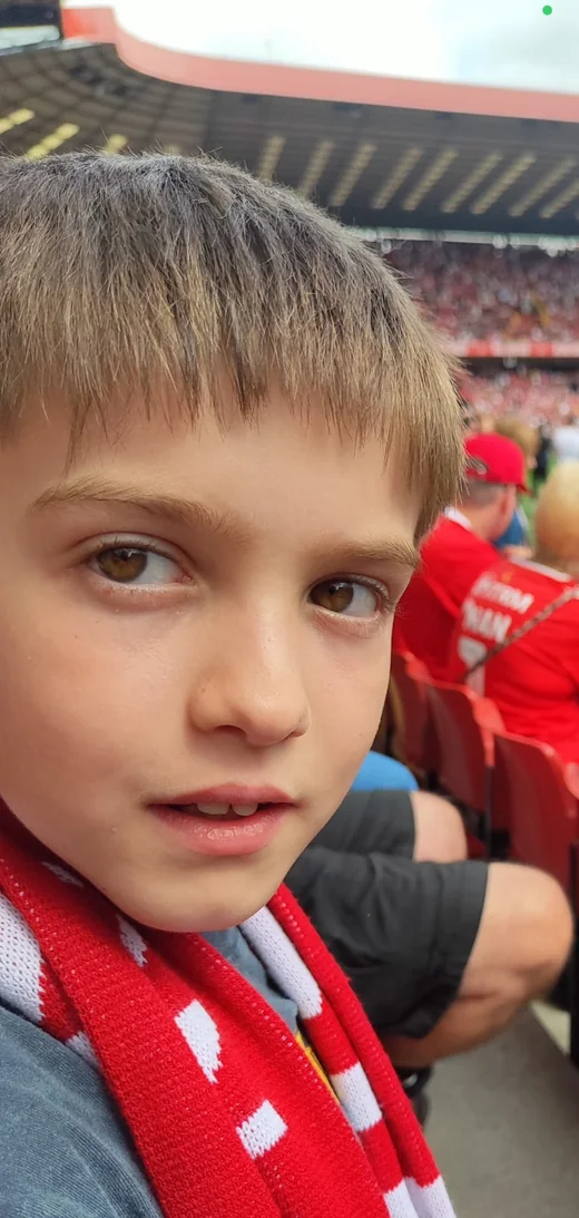 George at a football match, wearing a red and white scarf