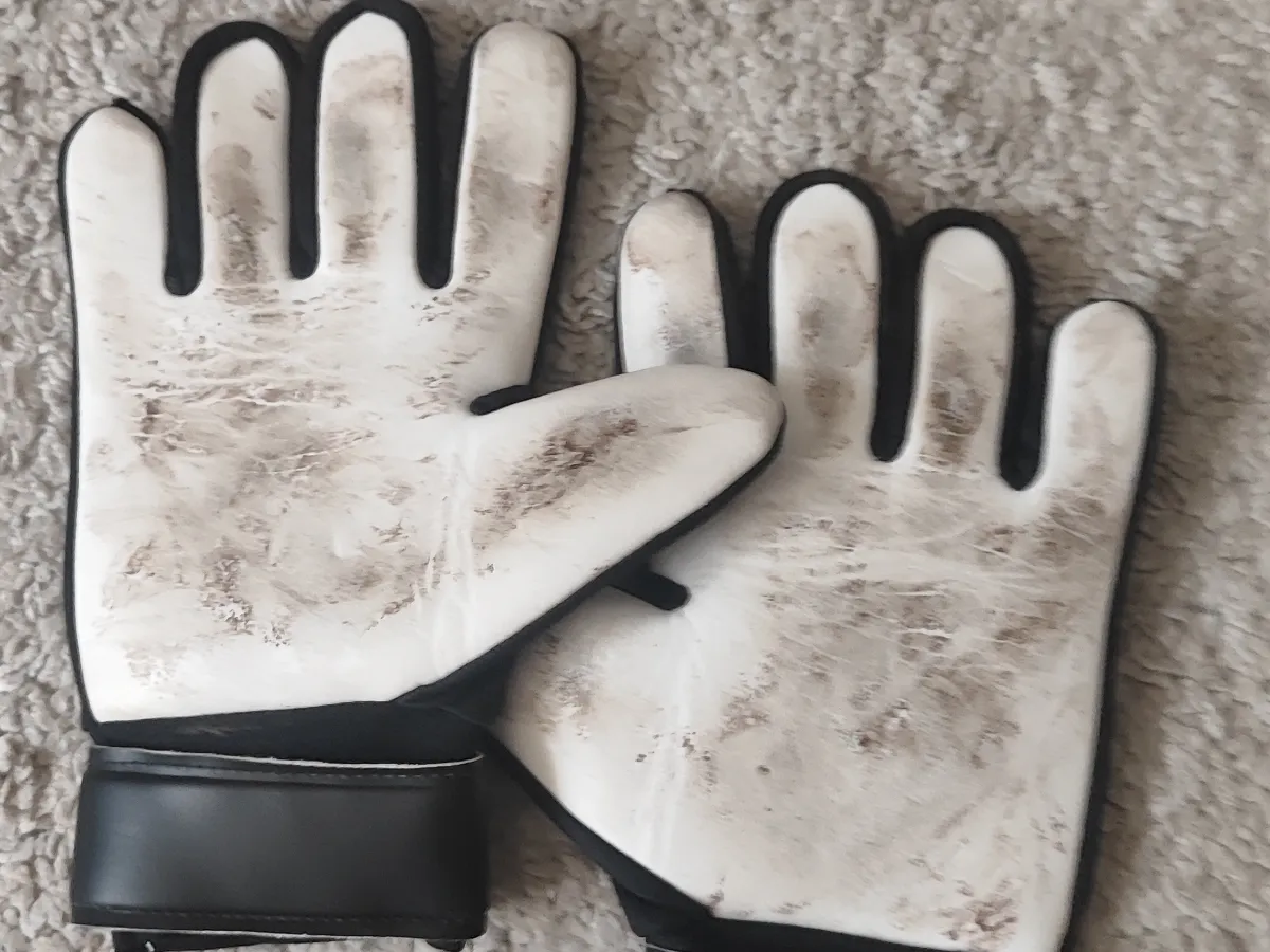 A pair of well-used white and black goalkeeper gloves